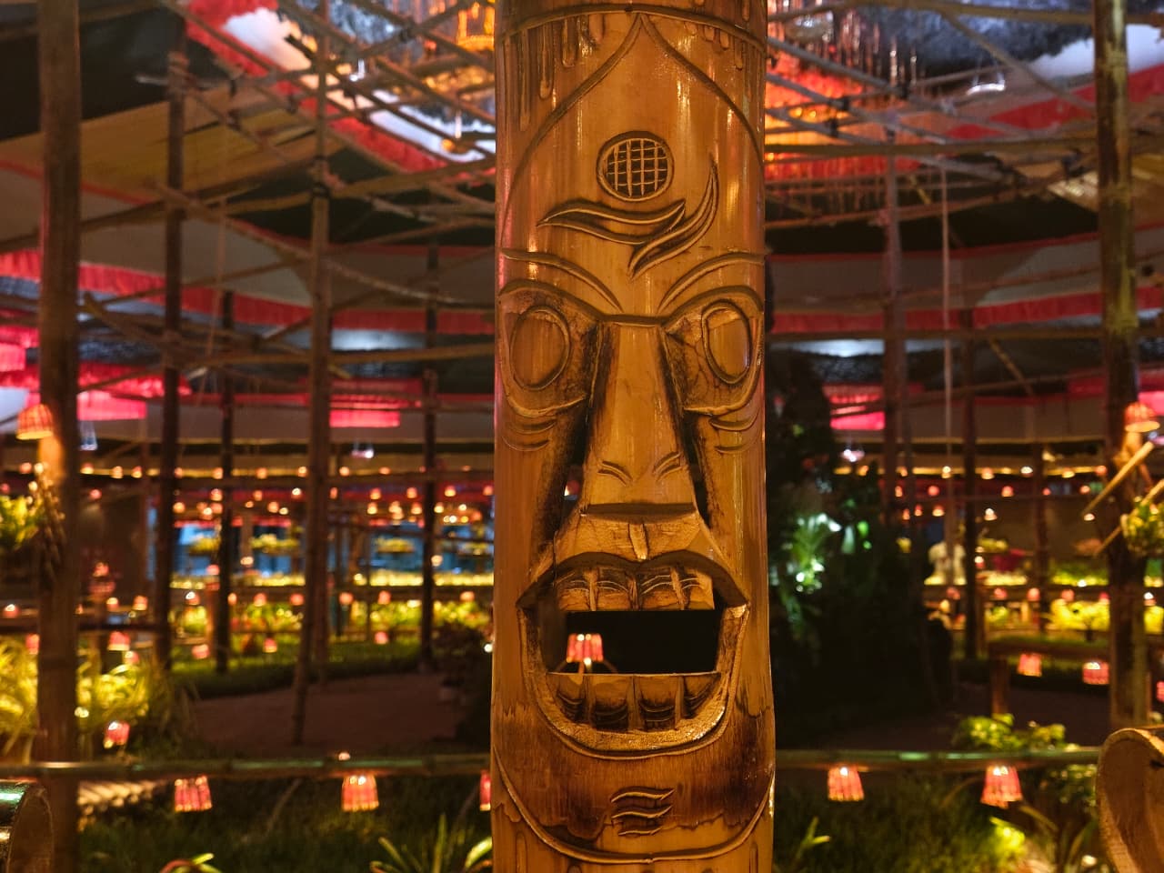 Close-up of a hand-carved bamboo totem face showing intricate artistry