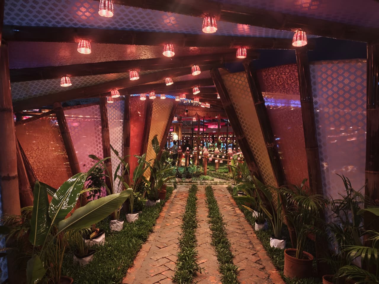Bamboo tunnel corridor lined with plants and lanterns