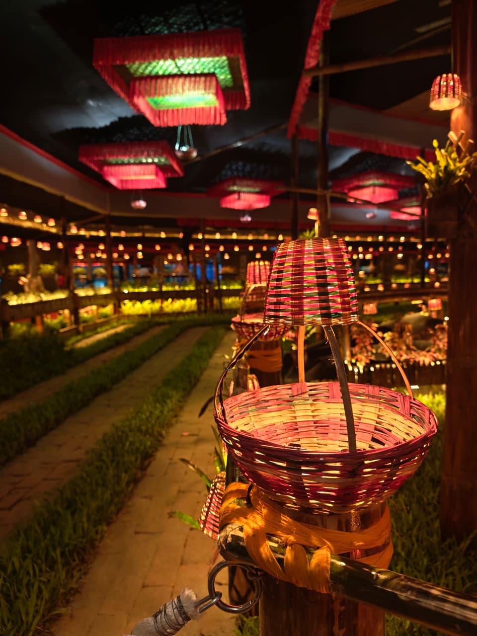 Woven bamboo basket lantern in close-up with red chandeliers in the background