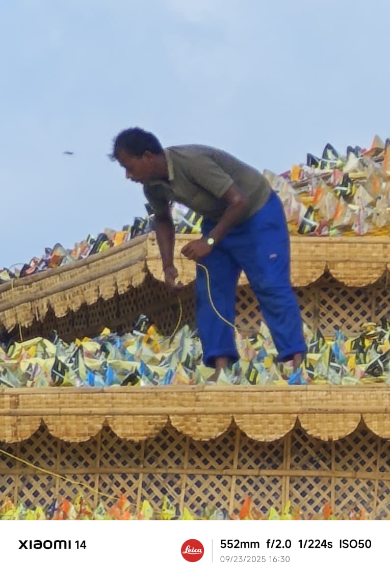 A karigar on the roof fitting woven bamboo panels